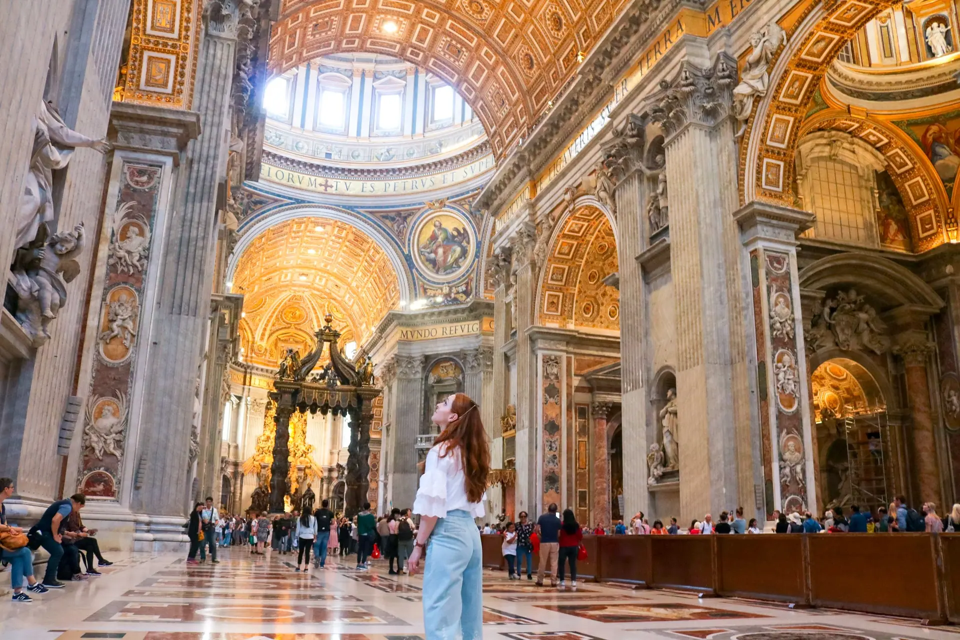Visitors in respectful attire walking through the Vatican Museums